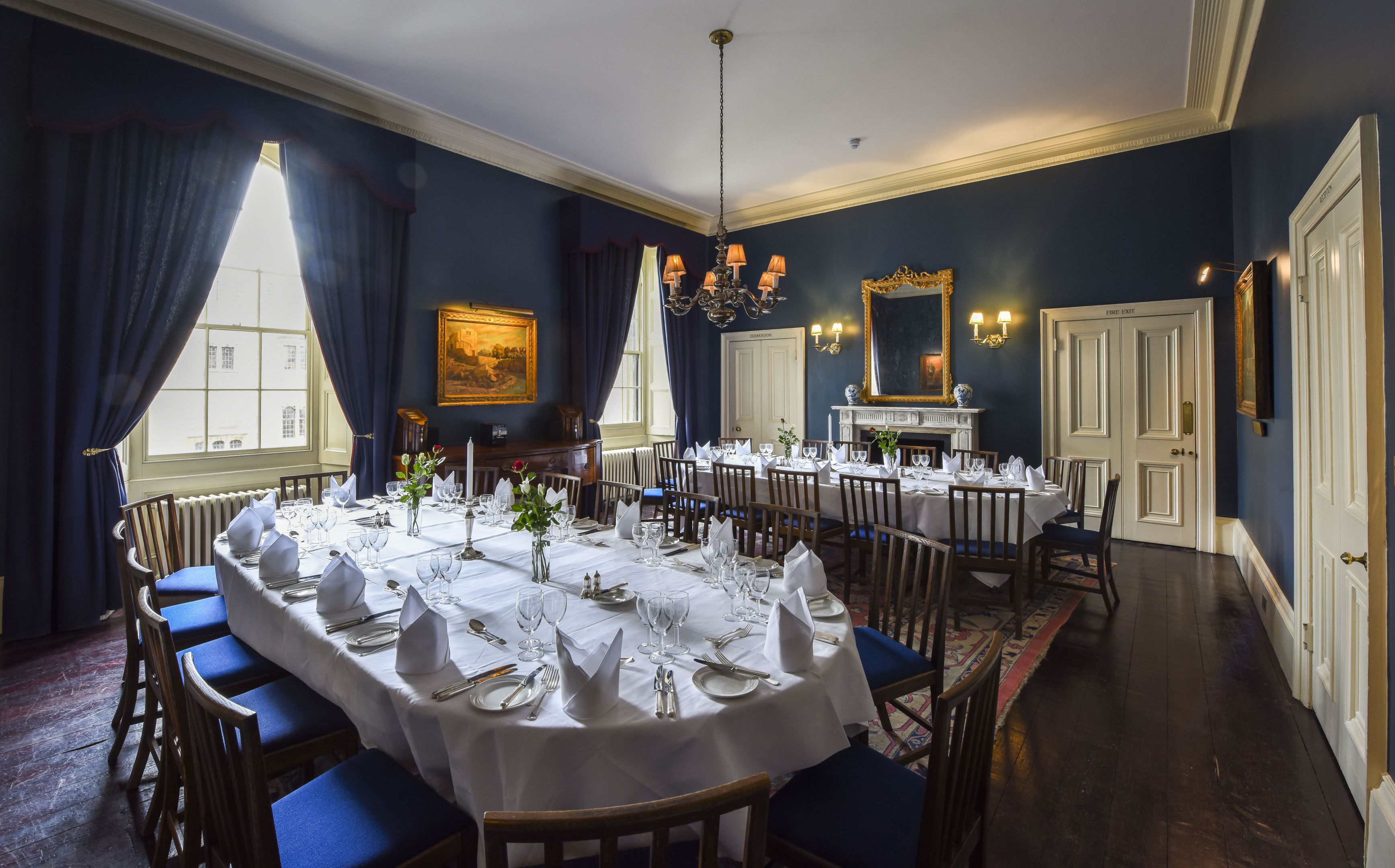 Blue dining room with 2 formally laid dining tables