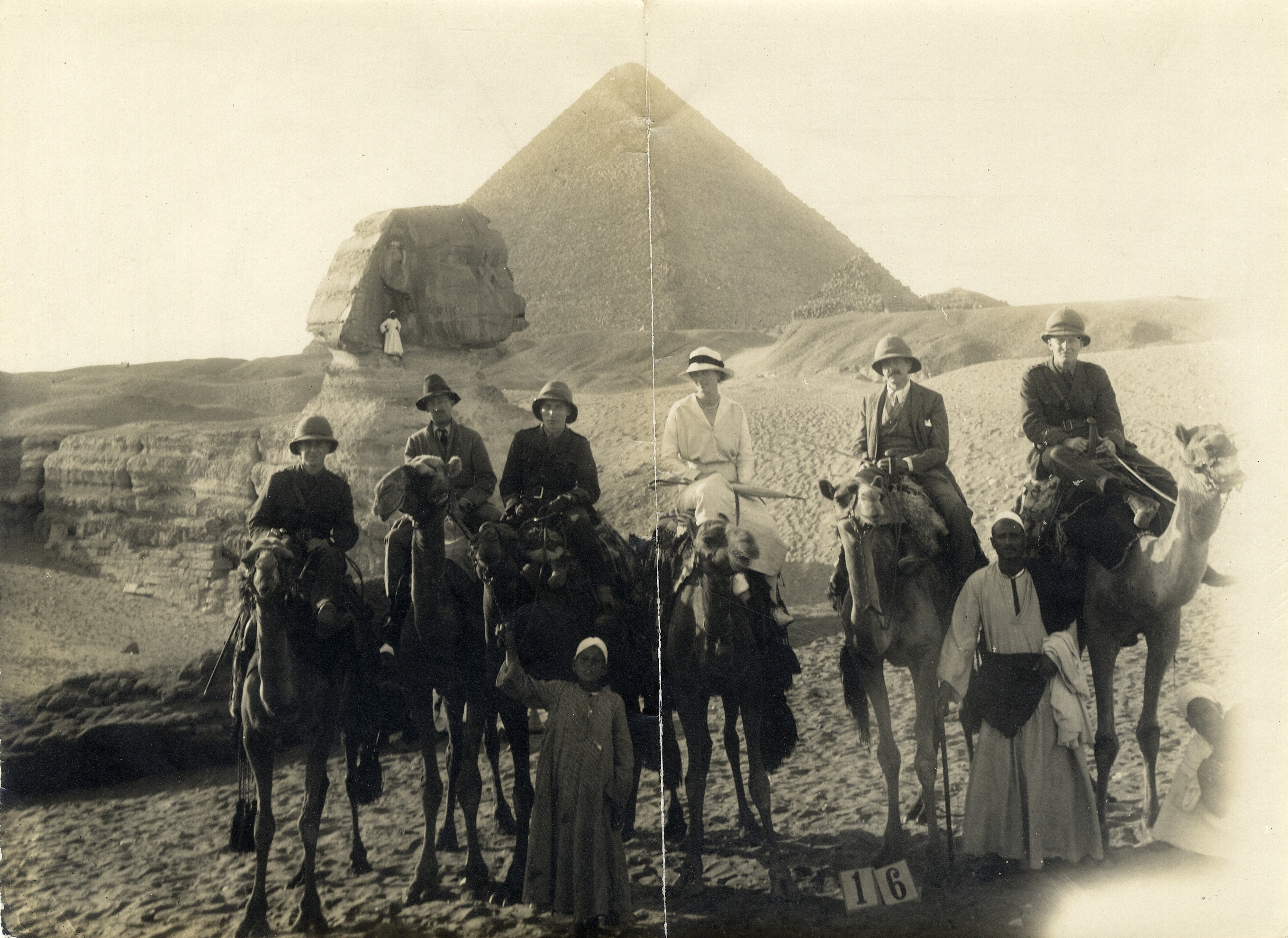 old photo of people on horse in front of pyramids