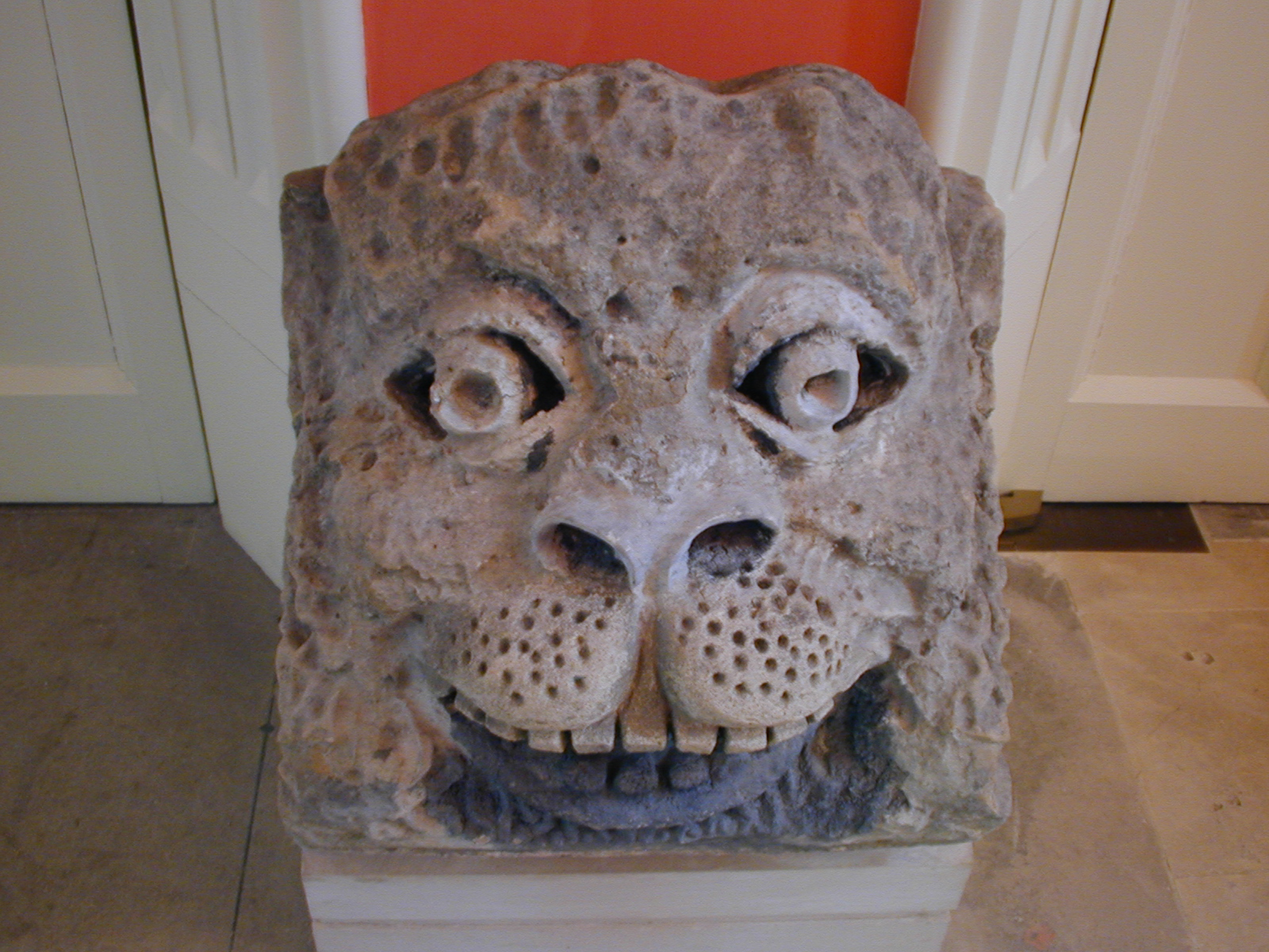 a stone lion head mounted on a plinth