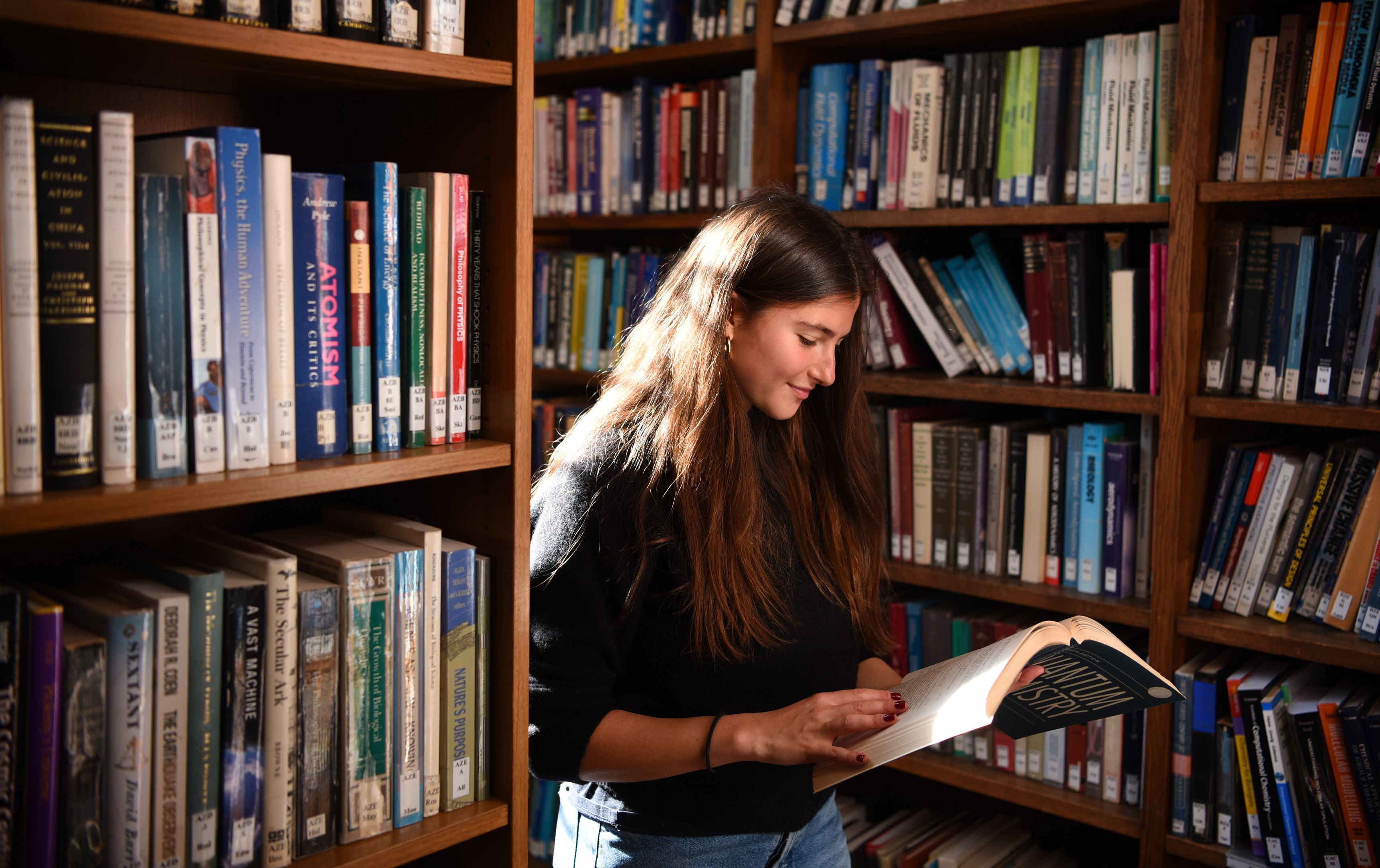 female-student-reading-a-text-book-in-the-library