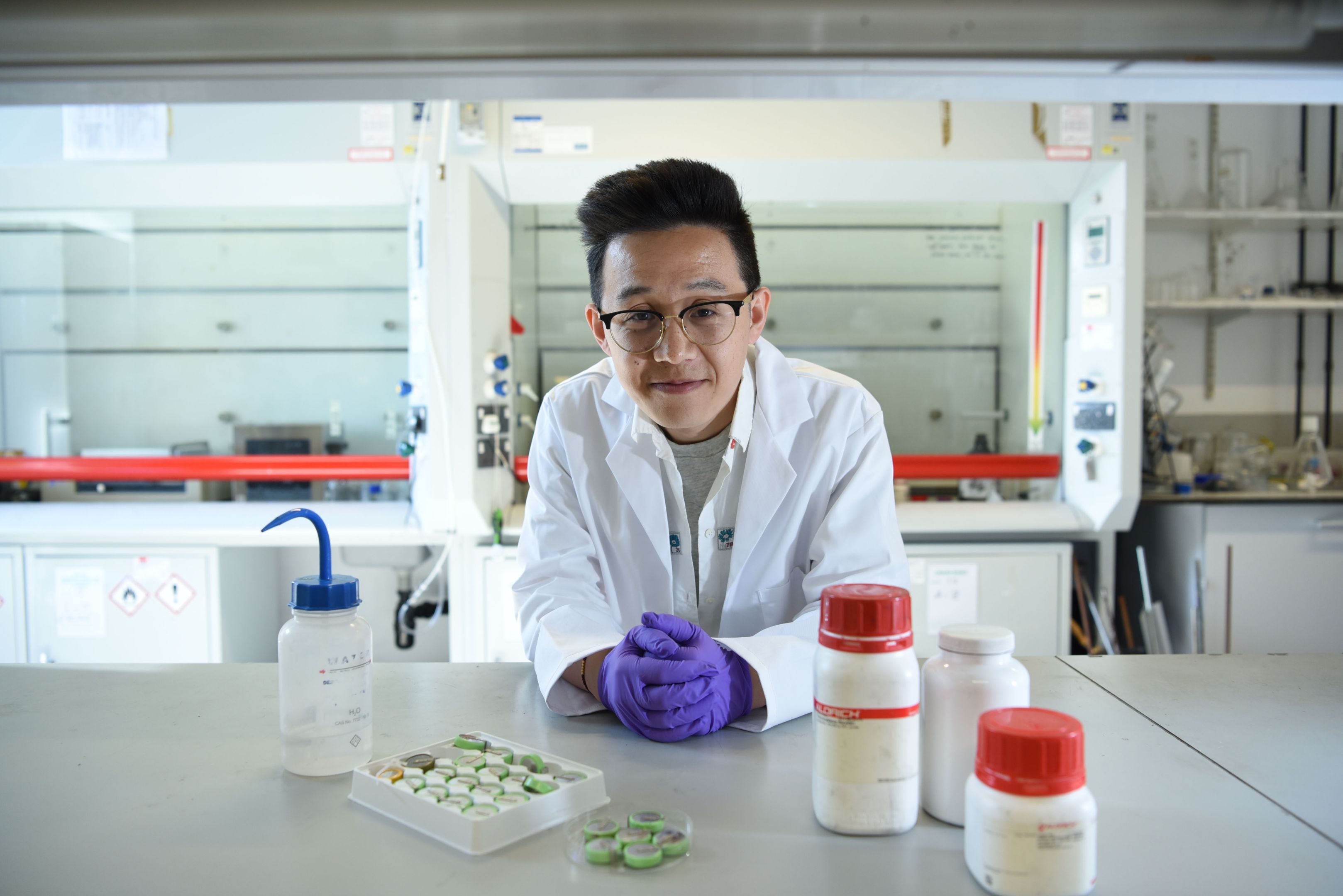 Zhuangnan Li standing over a bench in a laboratory