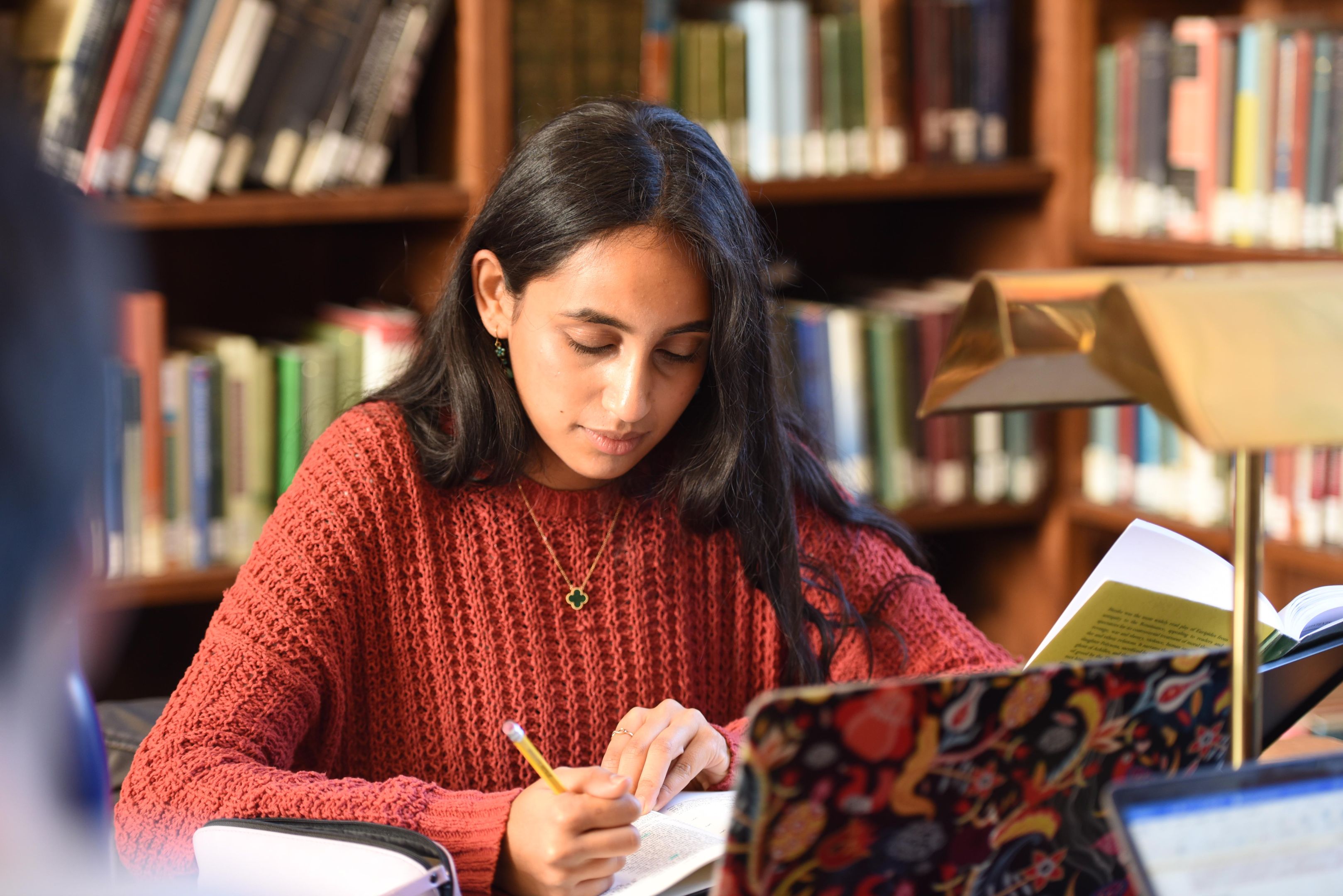 Female Graduate Student Working In Library