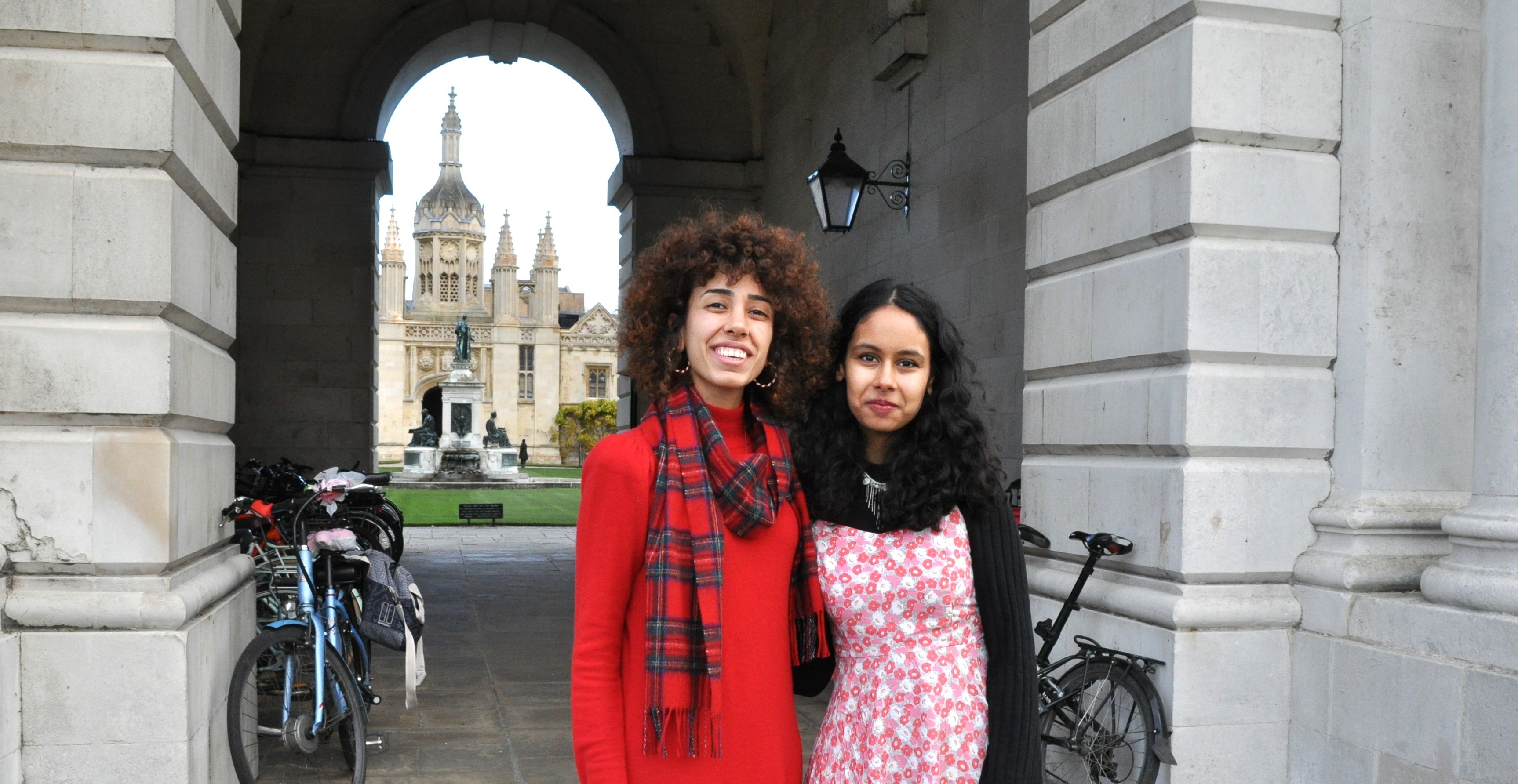 two students standing under an archway
