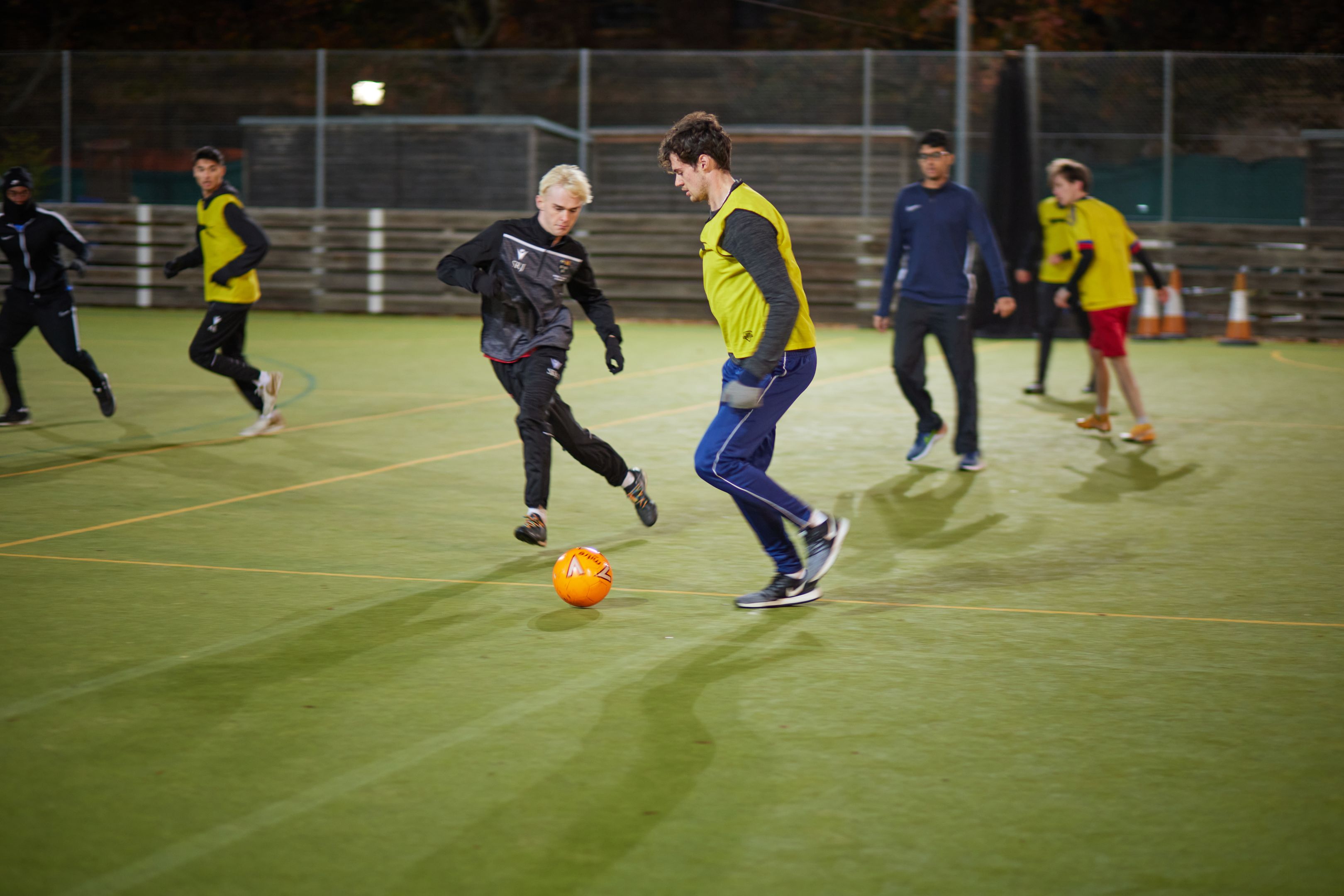 Students playing football at night