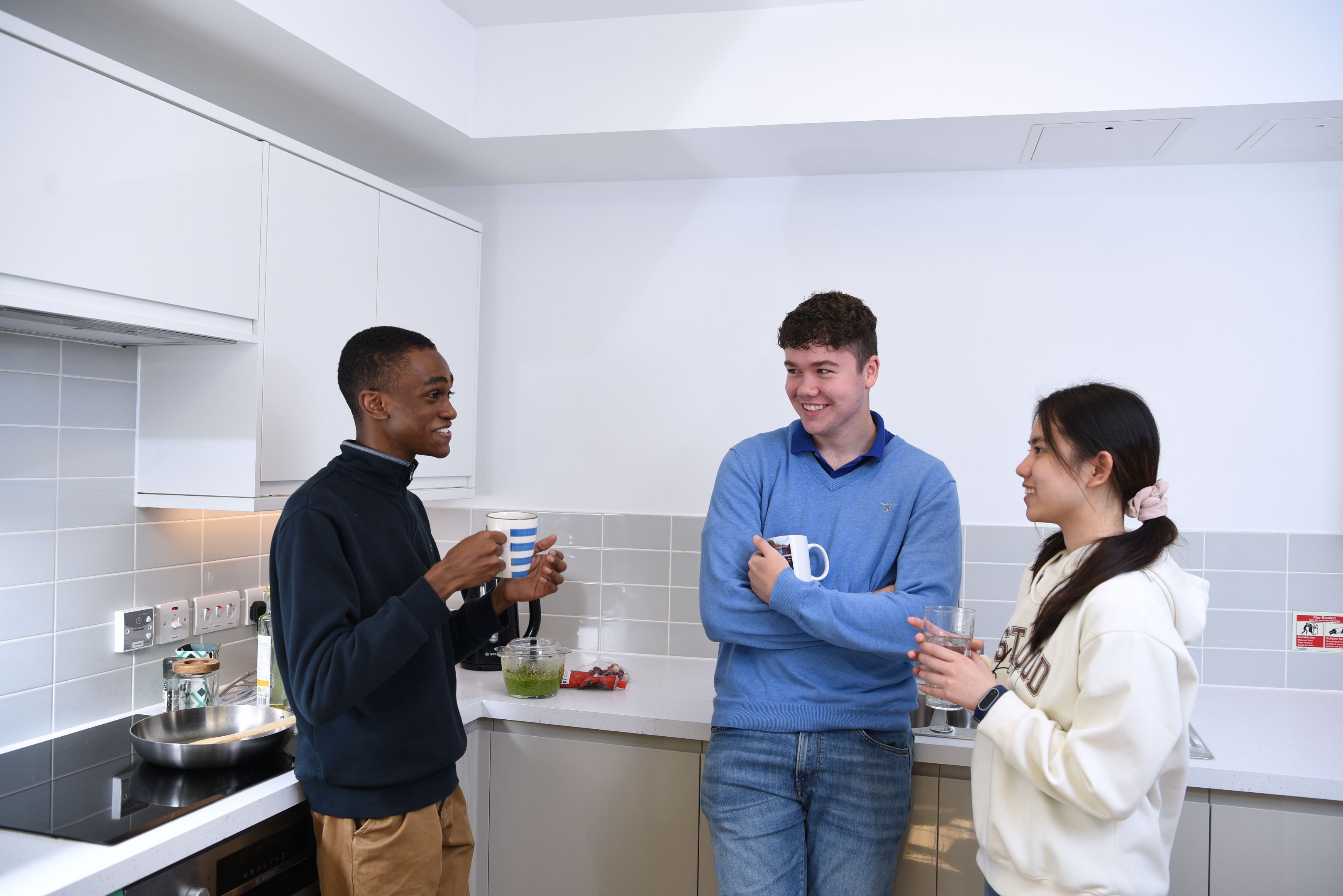 Three students in a modern kitchen