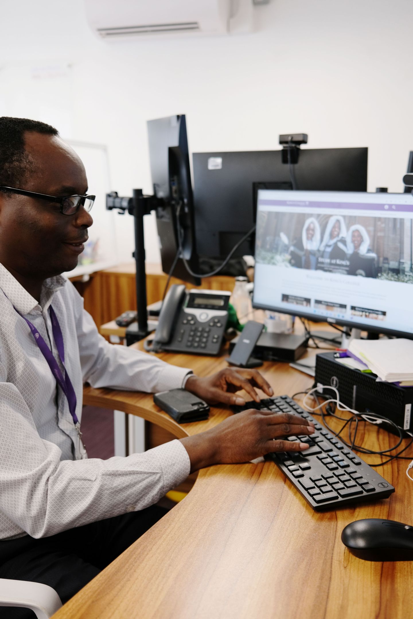 A man sat at his desk typing something on a computer